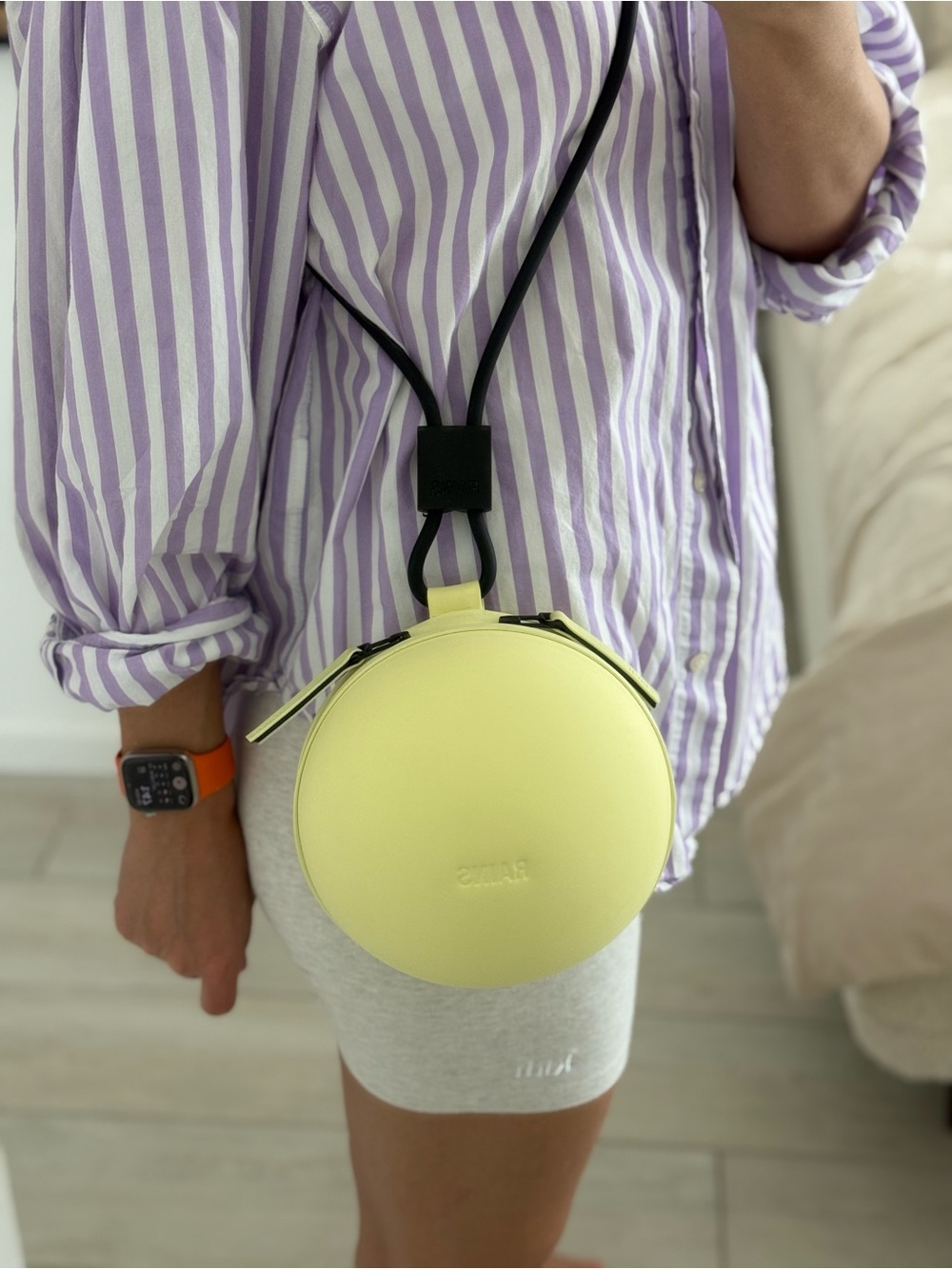 Rains Round Crossbody Bag in Pale Yellow with Black Strap